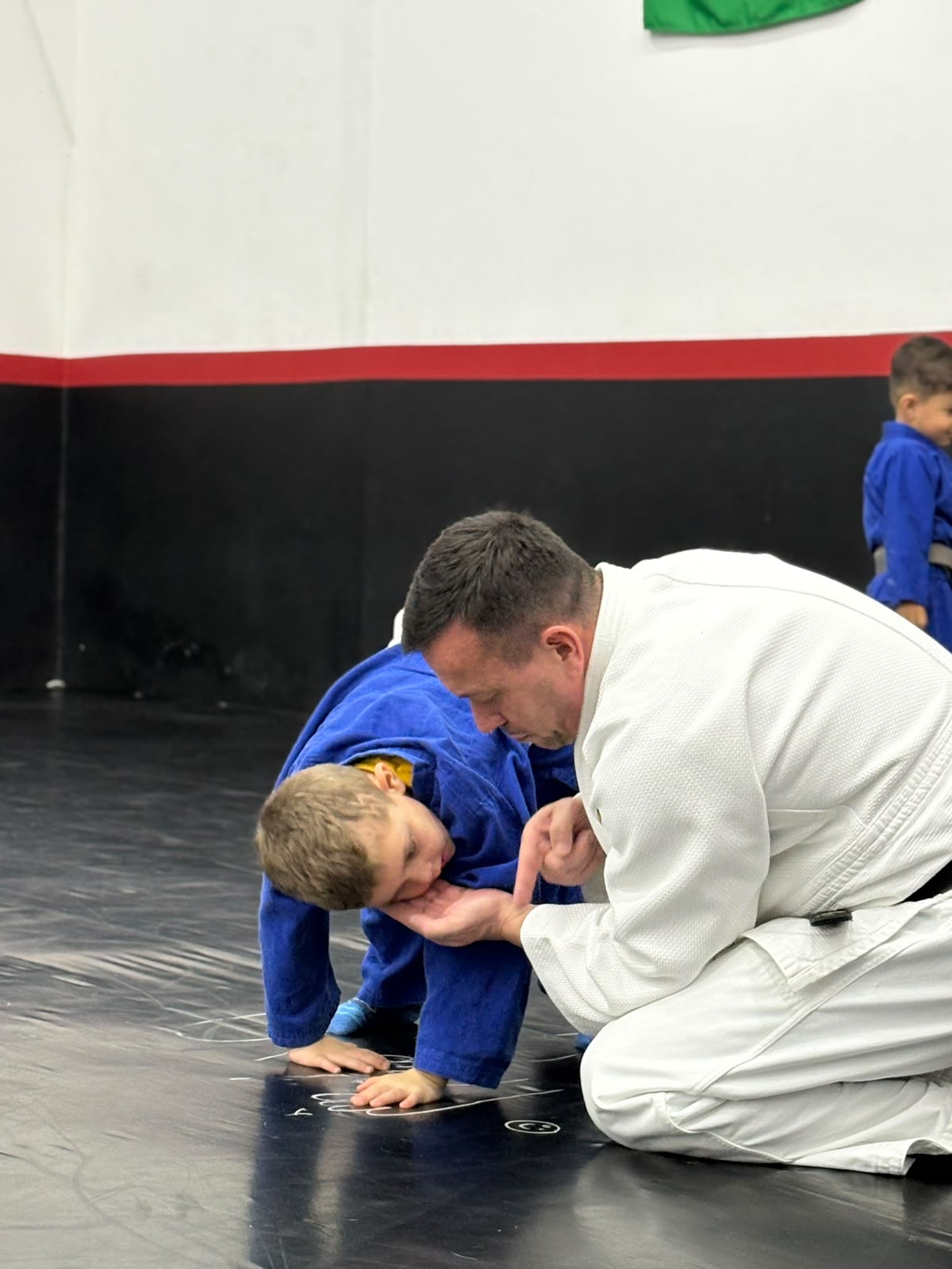 Sensei orientando um jovem judoca durante a aula